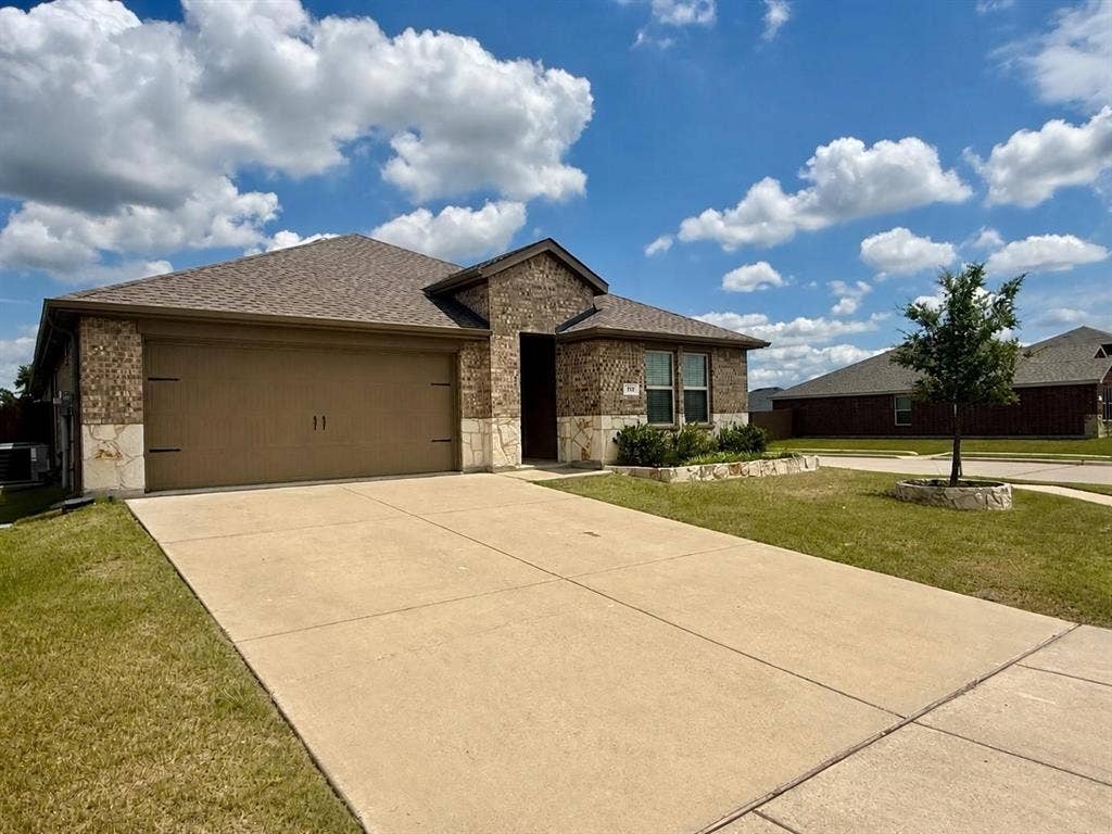 717 Cottonwood Way, Royse City, TX 75189 Brick and stone facade residence featuring a two-car garage with a brown door