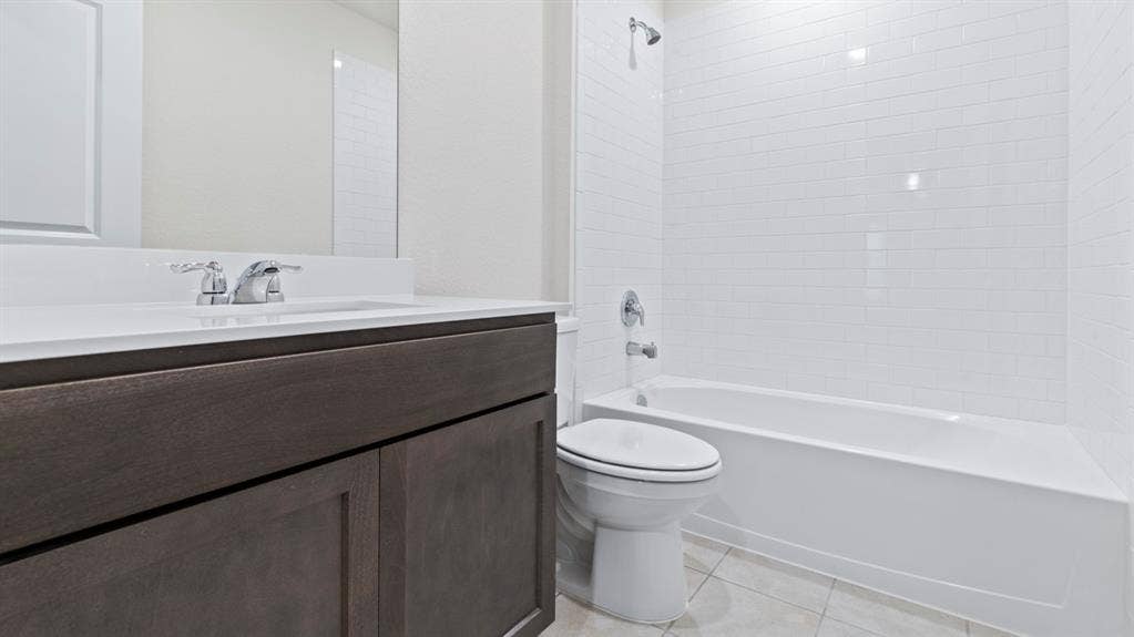 Bathroom featuring a deep brown wood-finish vanity with a white countertop, undermount sink, and chrome faucet
