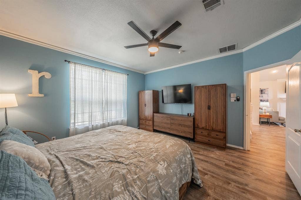 812 Chaparral Drive, Grand Prairie, TX 75052 Bedroom featuring wood-finish flooring, a ceiling fan, and crown molding
