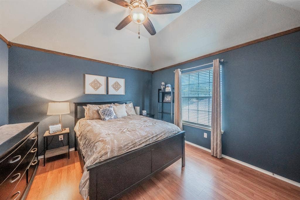 812 Chaparral Drive, Grand Prairie, TX 75052 Vaulted ceilings featuring a ceiling fan, a window with blinds and curtains, and wood-finish flooring