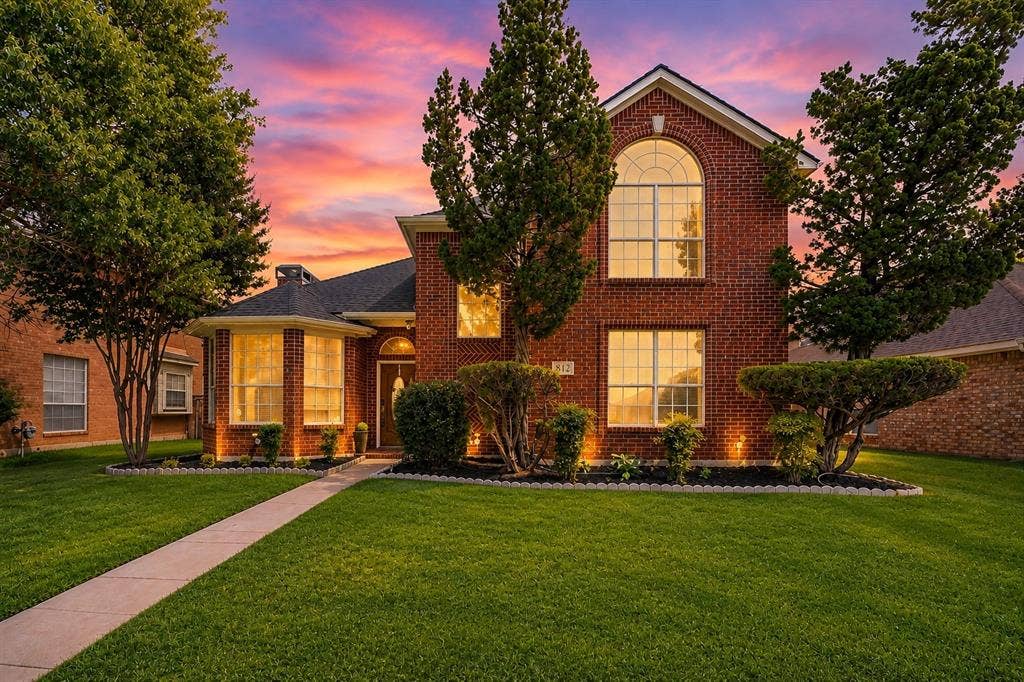 812 Chaparral Drive, Grand Prairie, TX 75052 Brick facade with arched window, bay window, front landscaping, and concrete pathway