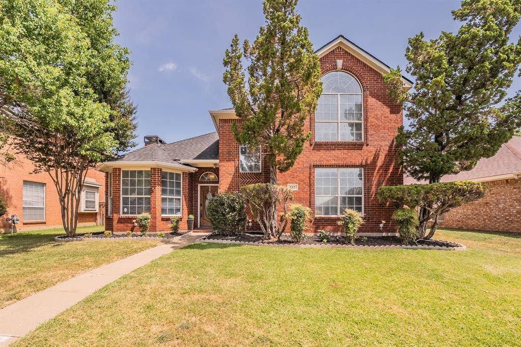812 Chaparral Drive, Grand Prairie, TX 75052 Two-story brick exterior featuring a prominent arched window, bay window, and gabled roofline