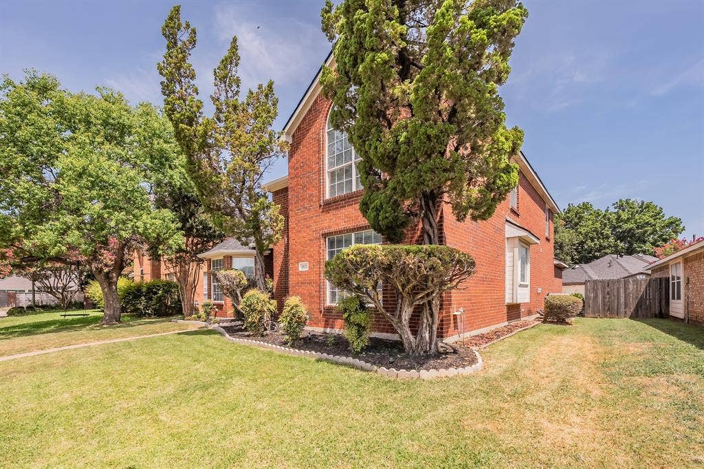 812 Chaparral Drive, Grand Prairie, TX 75052 Brick exterior featuring an arched window and a bay window
