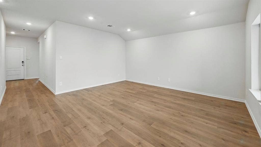 3057 Hidden Valley Drive, Lindale, TX 75771 Spacious room featuring wood-finish flooring, recessed lighting, white baseboards, and a white interior door