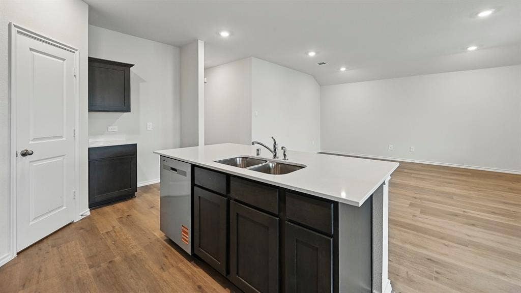 3057 Hidden Valley Drive, Lindale, TX 75771 Kitchen island with dual stainless steel sinks, a chrome faucet, and a built-in dishwasher
