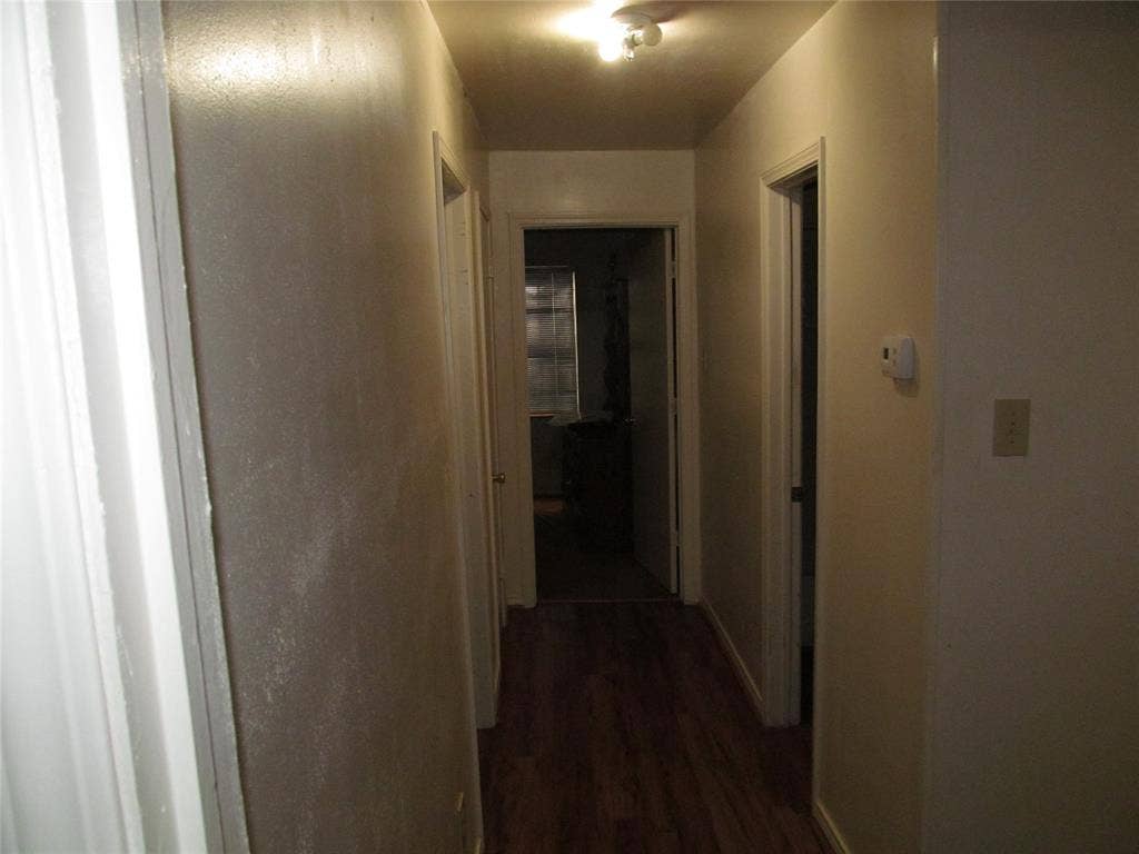 740 Emberwood Drive, Dallas, TX 75232 Hallway with wood-finish flooring and multiple doorways - BEHIND THE PHOTO IS BEDROOM #2 TO THE LEFT IN HALLWAY IS BEDROOM #3 , TO THE RIGHT IS THE SECOND FULL BATH WITH COMBO TUBSHOWER, AND AHEAD IS BEDROOM #4