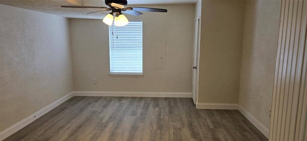 4809 Orchard Ridge Drive, Garland, TX 75043 Room featuring wood-finish flooring, a window with blinds, a ceiling fan with integrated lighting, and a white trim package