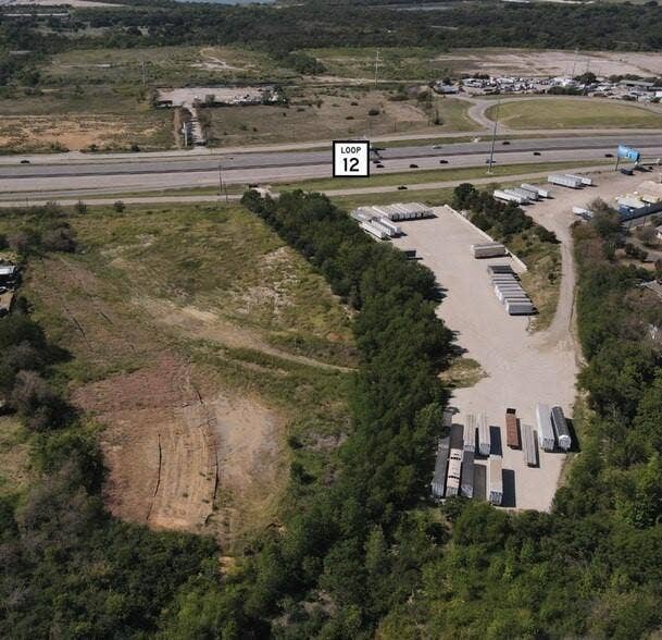 1200 N Walton Walker Boulevard, Dallas, TX 75211 Expansive undeveloped land featuring mature tree lines and direct access to a major thoroughfare