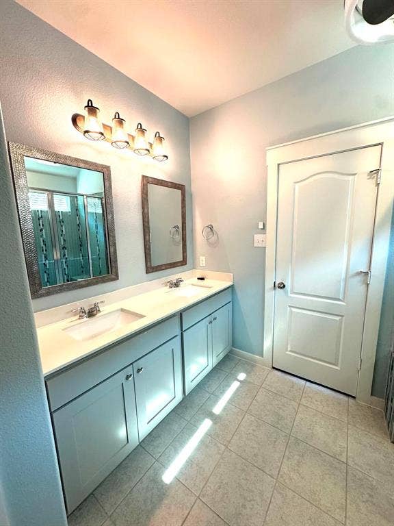 Fort Worth, TX 76123 Double vanity with light cabinetry, undermount sinks, and chrome faucets