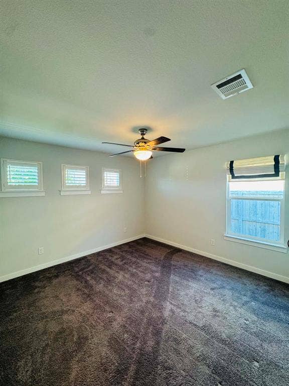Fort Worth, TX 76123 Plush grey carpeting and neutral wall tones define this room, featuring a ceiling fan with integrated lighting