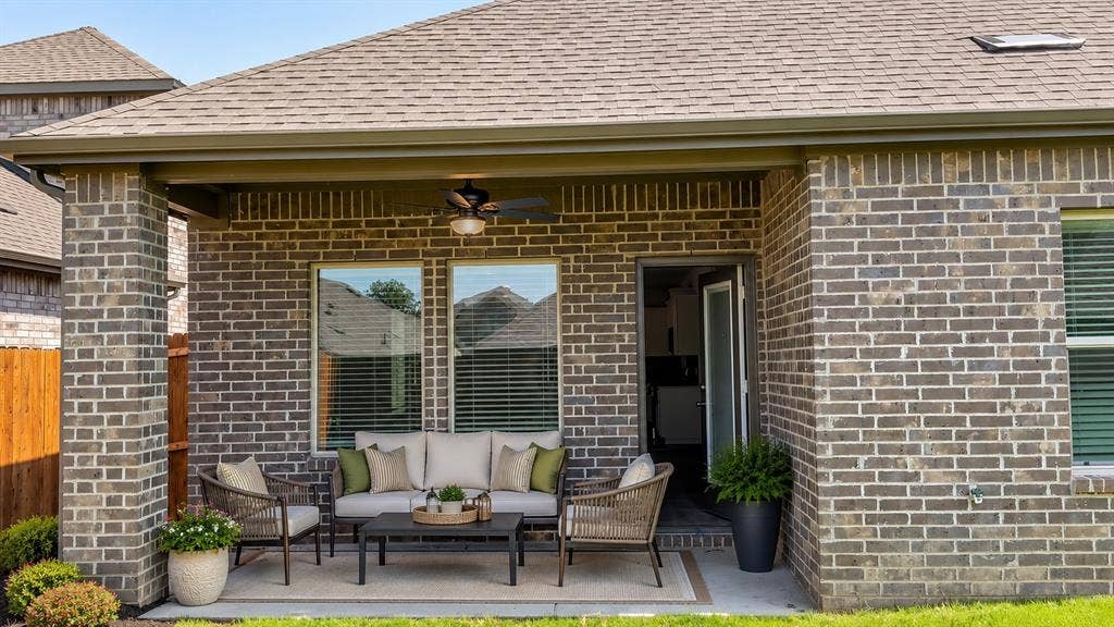 1317 crookpost Drive, Princeton, TX 75407 Covered patio featuring brick construction, a ceiling fan, asphalt shingles, and a privacy fence
