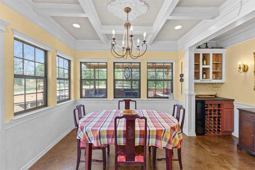 325 Bolton Road, Granbury, TX 76049 Coffered ceiling with decorative medallion, built-in wet bar with wine storage, multiple large windows, recessed lighting, and wood-finish flooring