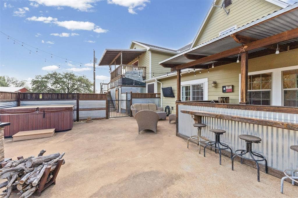 325 Bolton Road, Granbury, TX 76049 Covered outdoor bar, stone patio, fire pit, and hot tub built for entertaining. A true extension of the living space on this Granbury acreage.