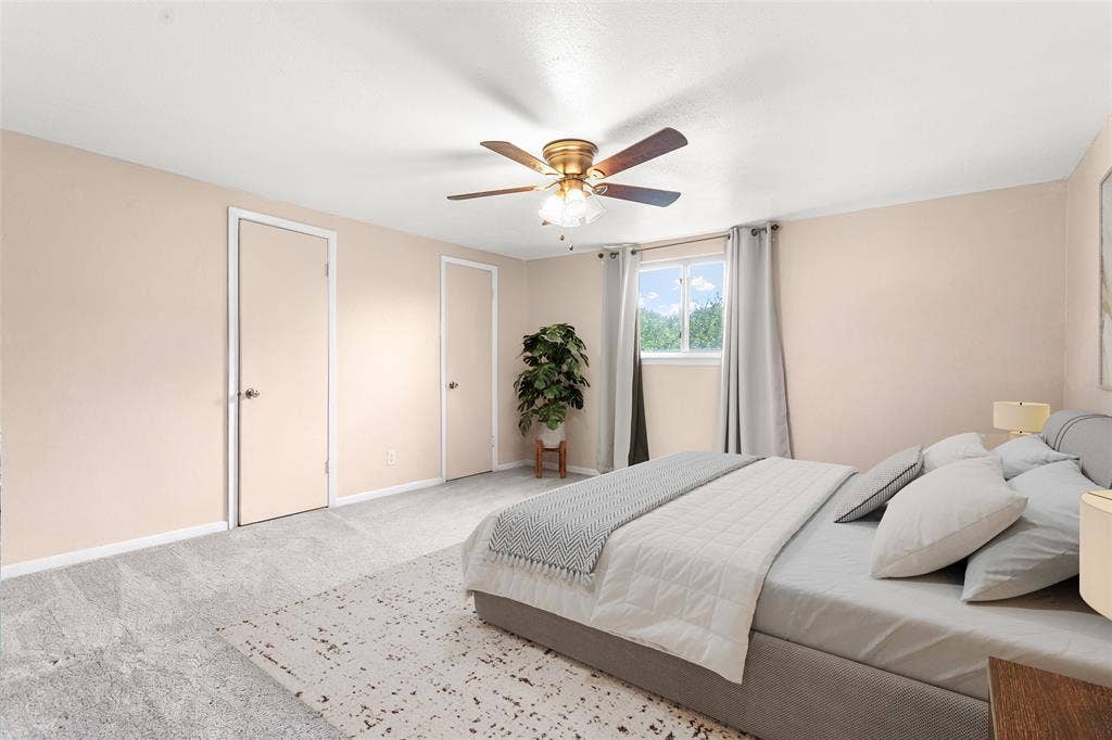 6930 Trailcrest Drive, Dallas, TX 75232 Virtually Staged Spacious room featuring light-toned walls, plush grey carpeting, a window with exterior visibility, and a ceiling fan with integrated lighting