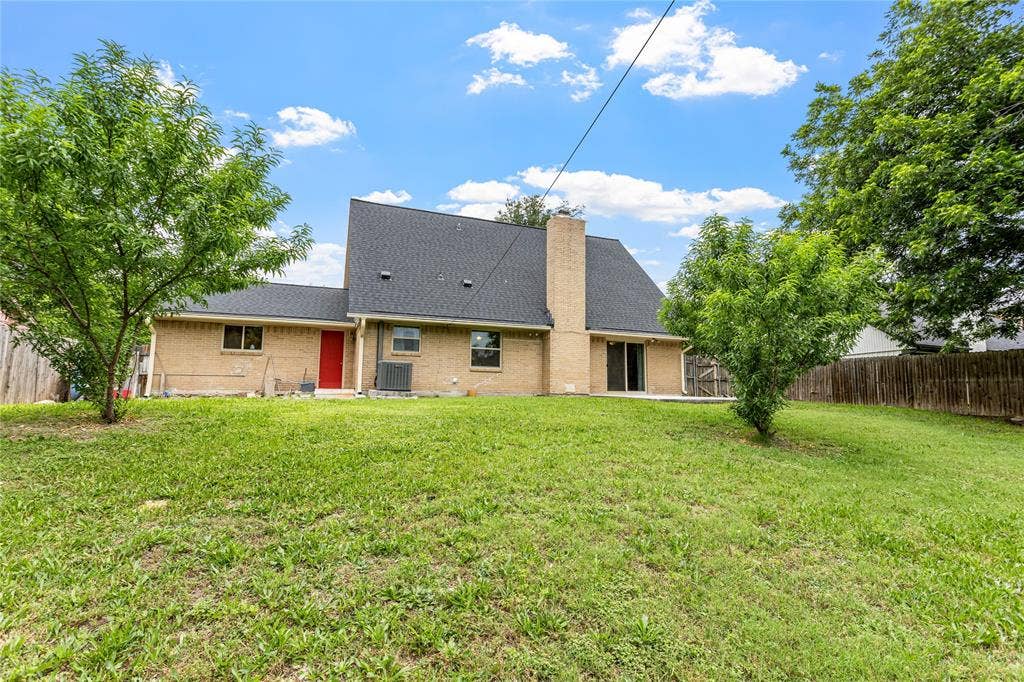 6930 Trailcrest Drive, Dallas, TX 75232 Expansive backyard featuring a lush lawn, mature trees, and a privacy fence