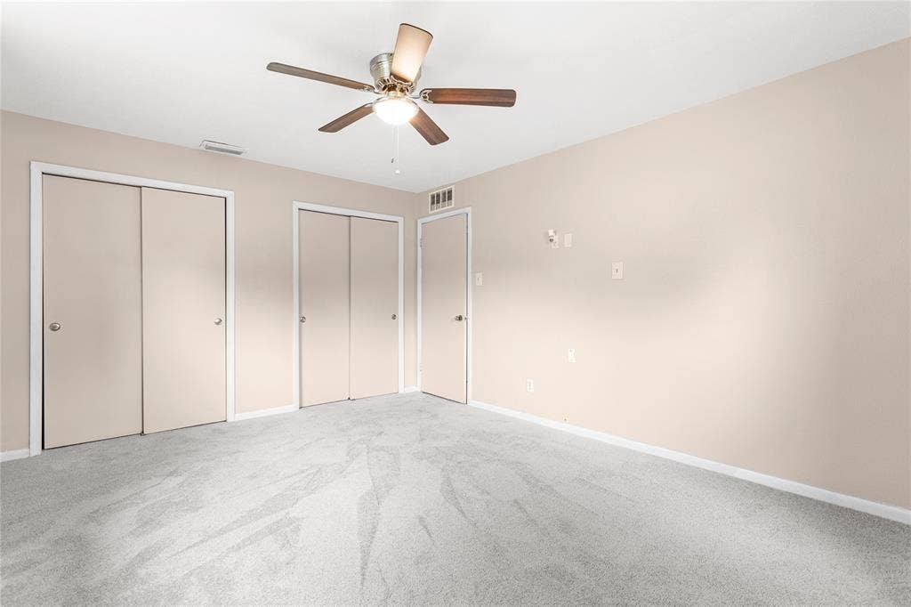 6930 Trailcrest Drive, Dallas, TX 75232 Spacious room featuring light-toned walls, plush grey carpeting, and a ceiling fan with integrated lighting