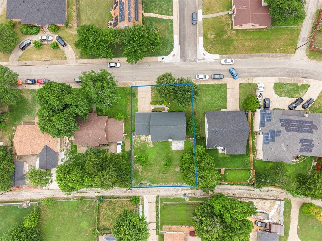 6930 Trailcrest Drive, Dallas, TX 75232 Aerial perspective showcasing a residential property with a dark shingle roof and a concrete driveway