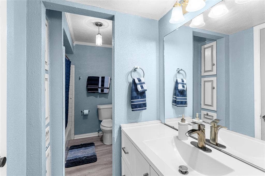 6930 Trailcrest Drive, Dallas, TX 75232 Bathroom vanity with a large mirror, integrated sink, and brushed nickel fixtures