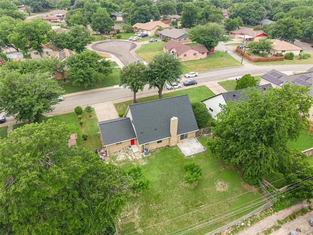 6930 Trailcrest Drive, Dallas, TX 75232 Single-story residence with a dark shingle roof, a prominent chimney, and a red front door
