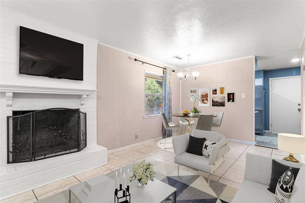 6930 Trailcrest Drive, Dallas, TX 75232 Virtually Staged Spacious living area featuring a white brick fireplace with a decorative screen, tile flooring, and a dining area with a chandelier