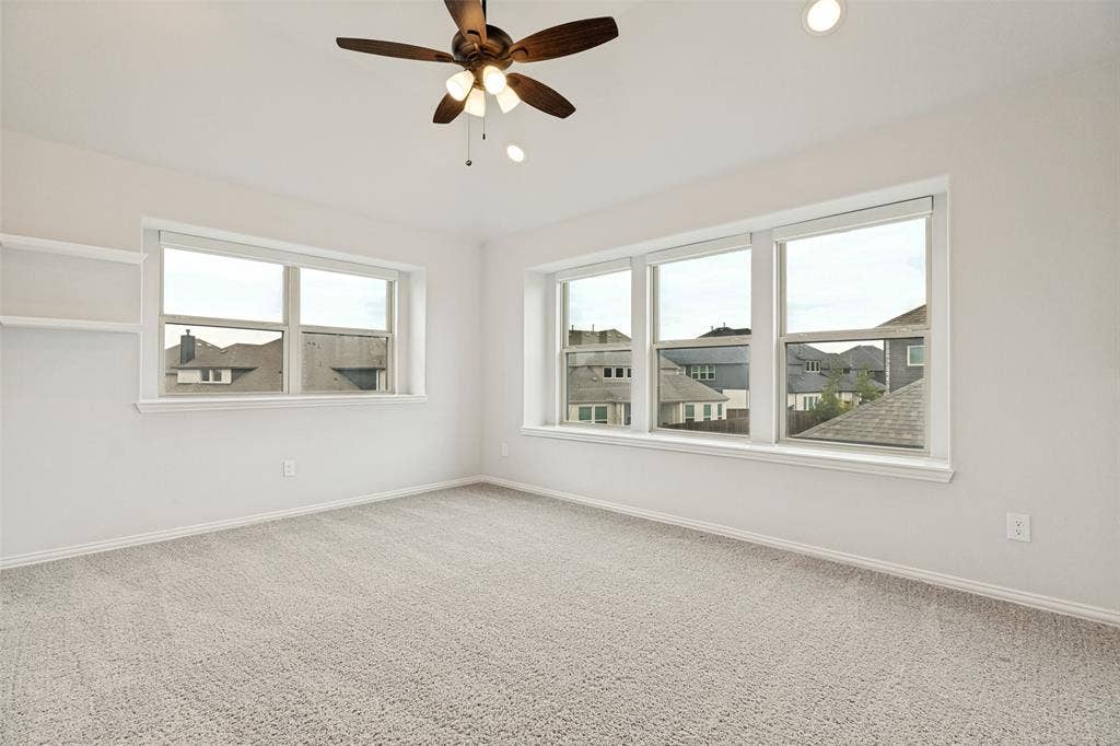 5405 Pooley Lane, McKinney, TX 75071 Carpeted room featuring multiple windows, a ceiling fan with integrated lighting, recessed lighting, and built-in shelving