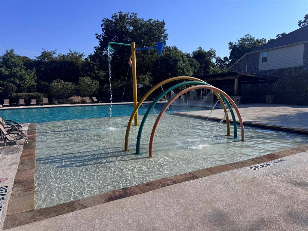 5405 Pooley Lane, McKinney, TX 75071 Community Pool area featuring a splash pad, main swimming pool, and pergola-covered patio