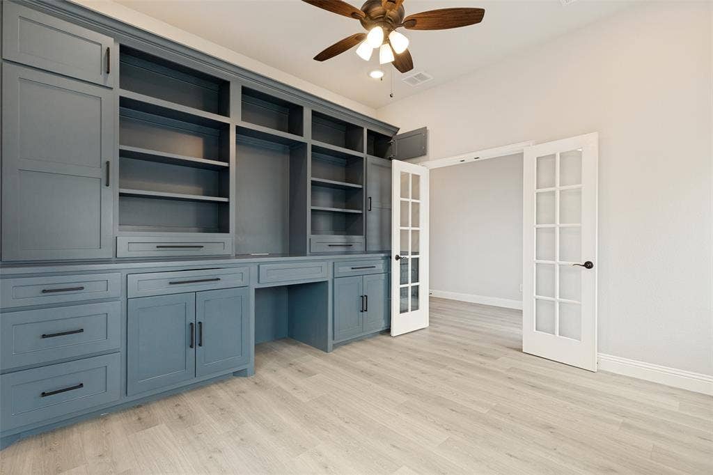 5405 Pooley Lane, McKinney, TX 75071 Built-in cabinetry in a muted blue finish featuring open shelving, enclosed storage, and desk space