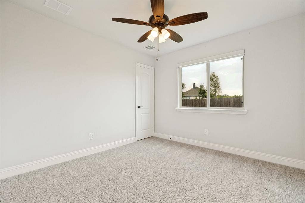 5405 Pooley Lane, McKinney, TX 75071 Bright interior space featuring light-colored carpet flooring, a multi-pane window, and a ceiling fan with integrated lighting