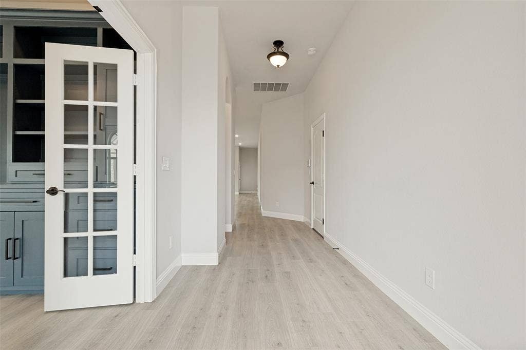 5405 Pooley Lane, McKinney, TX 75071 French doors with grid lites open to built-in cabinetry featuring open shelving and closed storage