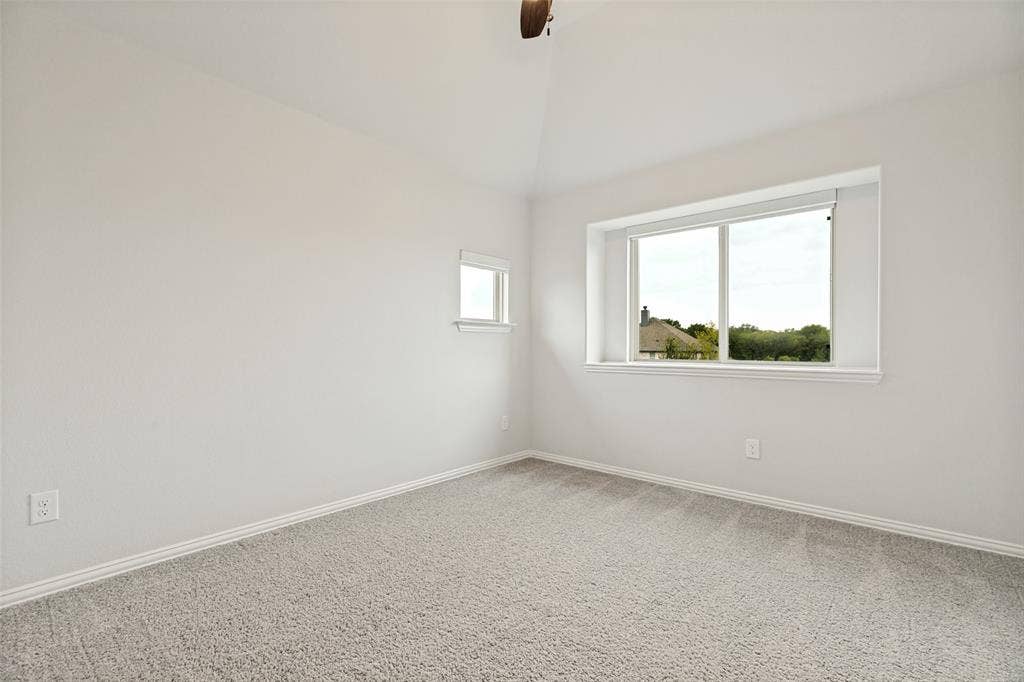 5405 Pooley Lane, McKinney, TX 75071 Room featuring light gray carpeting, vaulted ceiling, and white painted walls