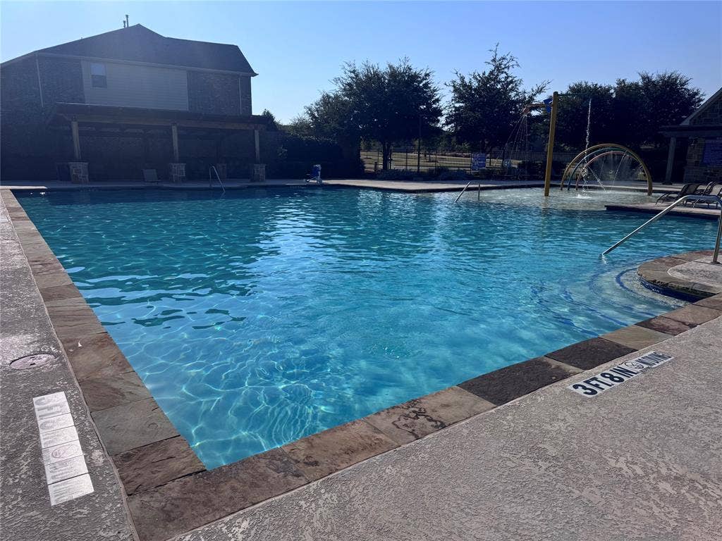 5405 Pooley Lane, McKinney, TX 75071 Community swimming pool featuring a shallow water play area, integrated water features, and a shaded pergola
