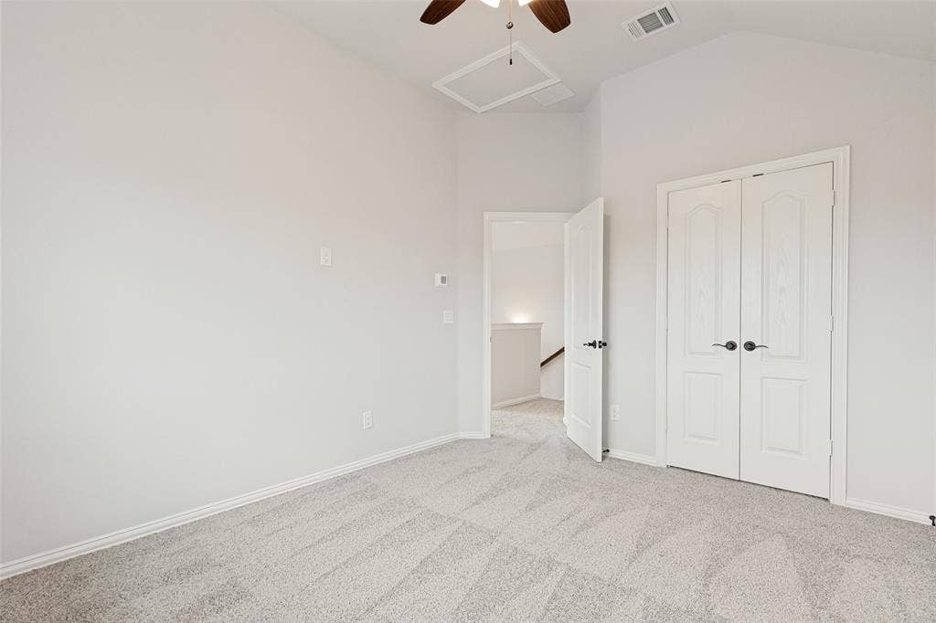 5405 Pooley Lane, McKinney, TX 75071 Room featuring a vaulted ceiling with a ceiling fan, light gray carpet, white baseboards, and a pair of white bifold doors with black hardware