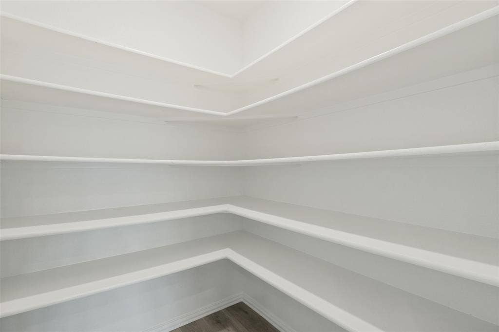5405 Pooley Lane, McKinney, TX 75071 Walk-in pantry featuring extensive white shelving and wood-finish flooring