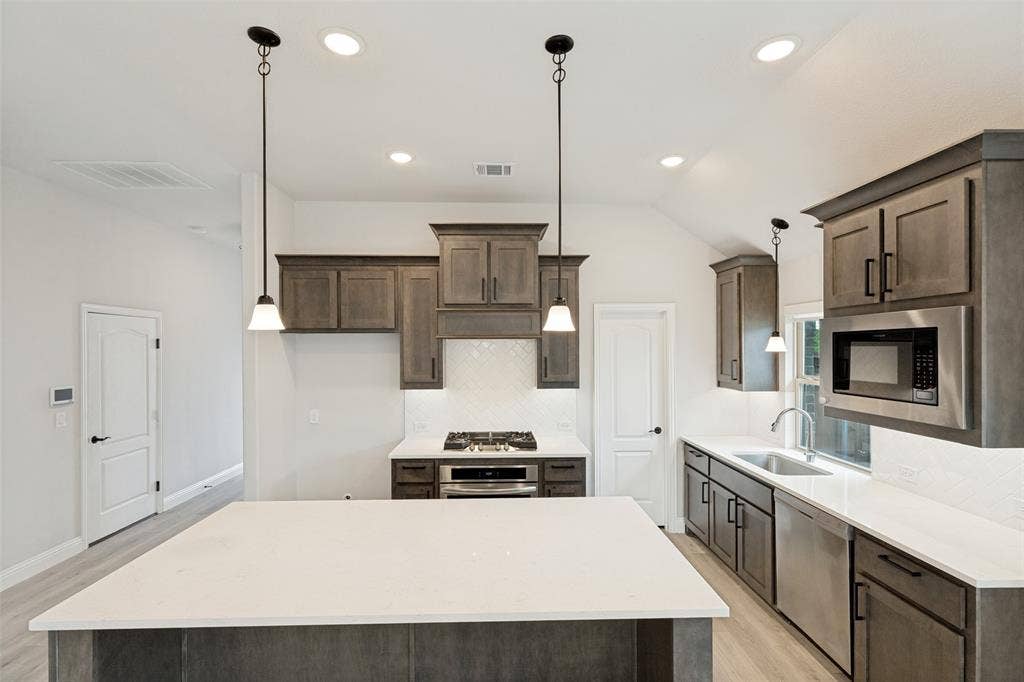 5405 Pooley Lane, McKinney, TX 75071 Spacious kitchen featuring an expansive island with a white countertop, wood-finish flooring, and recessed lighting