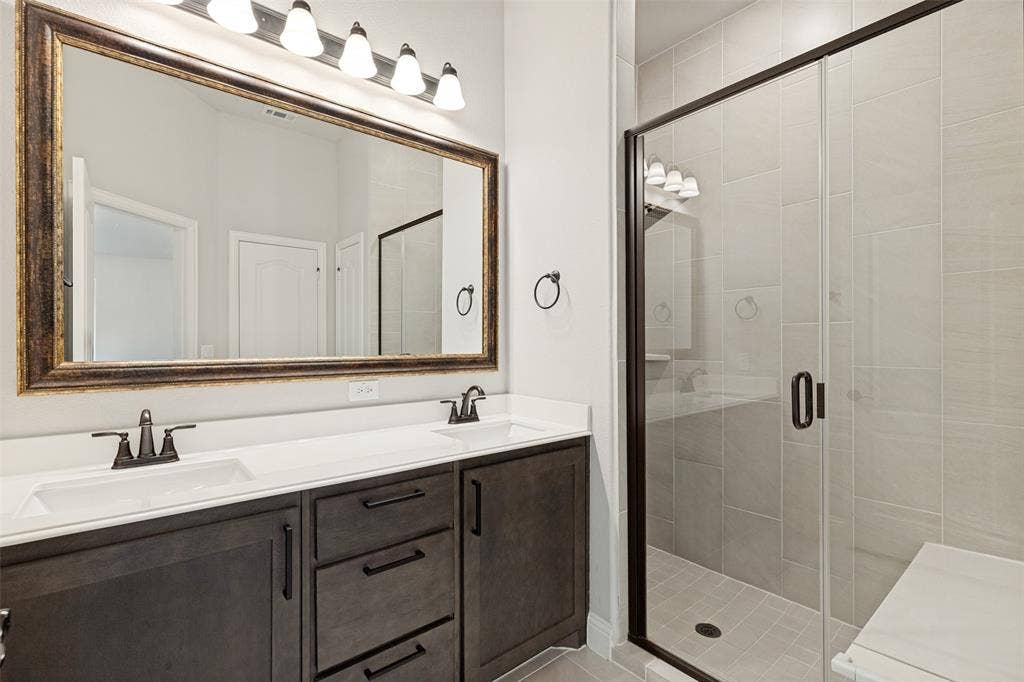 5405 Pooley Lane, McKinney, TX 75071 Modern bathroom featuring a dual vanity with dark wood-finish cabinetry, white countertops, and undermount sinks