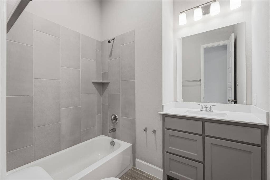 Bathroom featuring a tub/shower combination with large format subway tile surround and integrated corner shelf