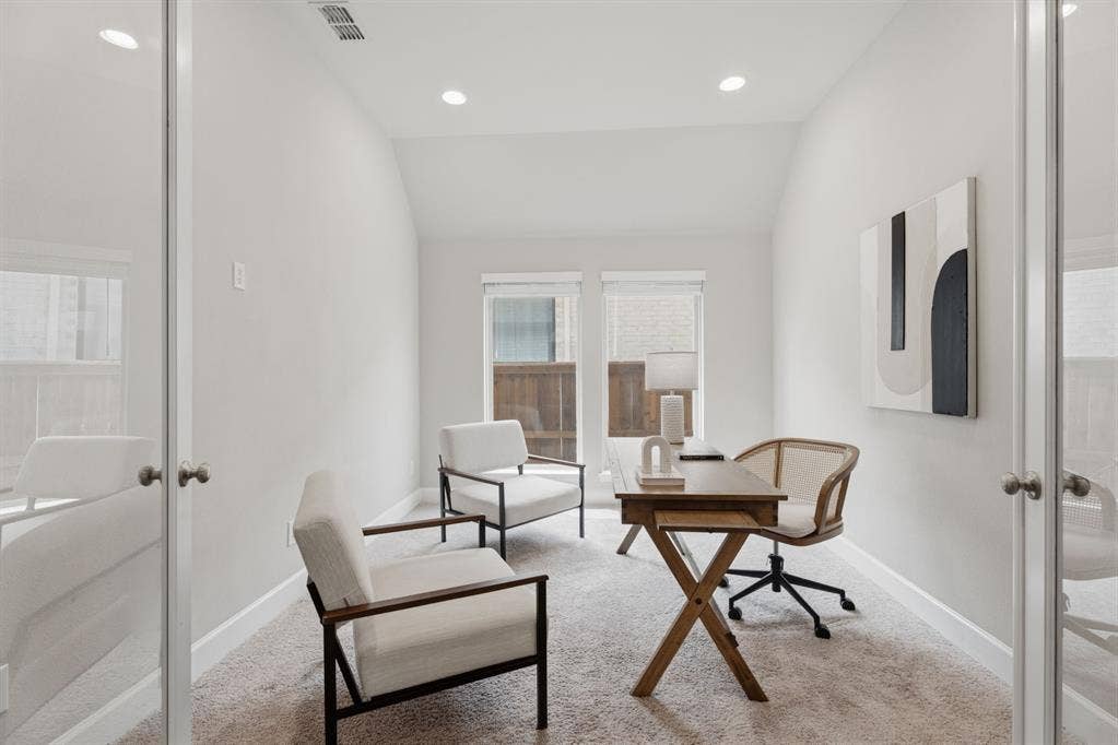 Light-filled room featuring a vaulted ceiling and recessed lighting
