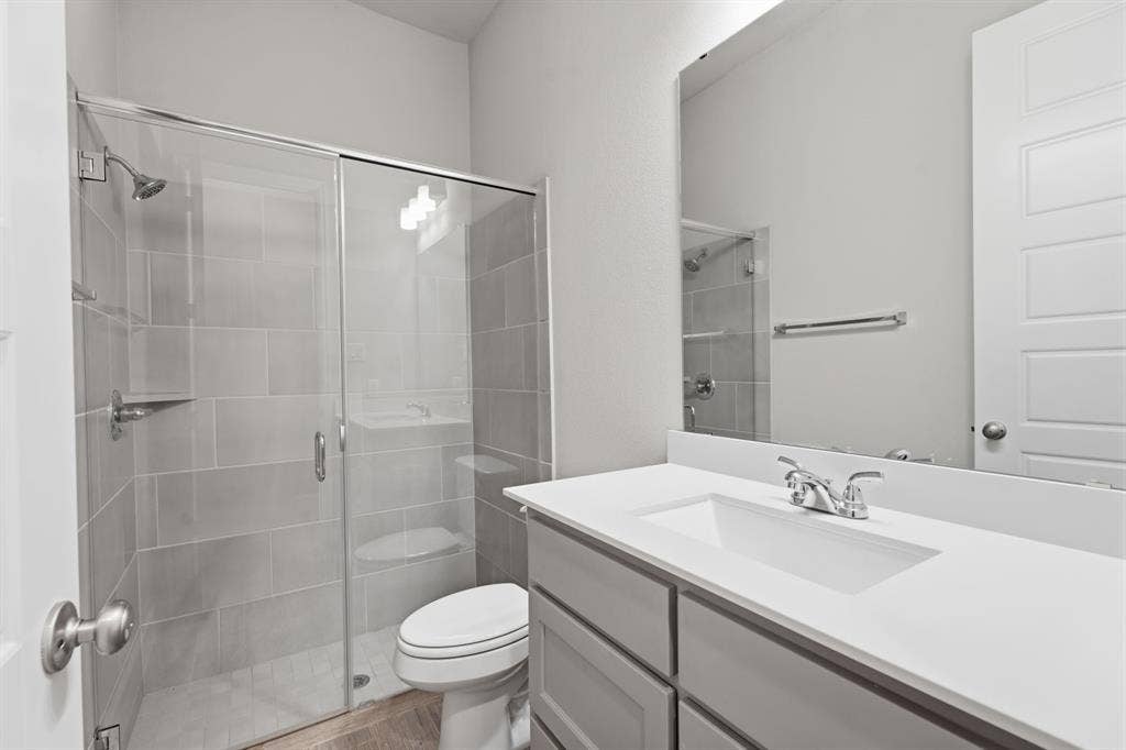 Contemporary bathroom featuring a spacious glass-enclosed shower with subway tile surround, a built-in shower niche, and a chrome shower head