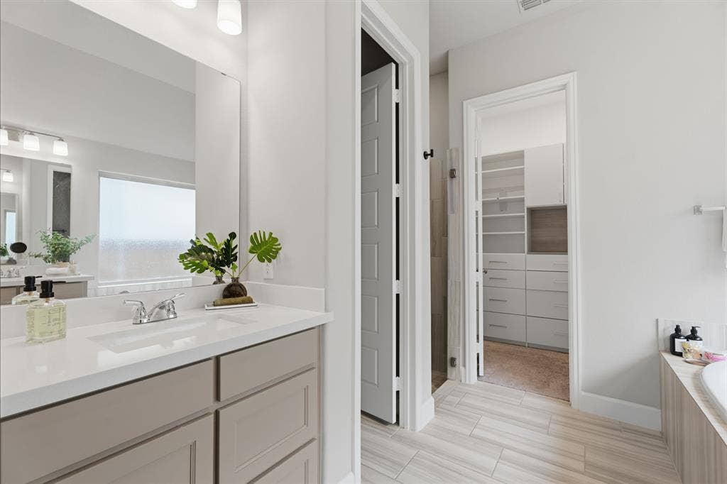 Bathroom featuring a light-toned vanity with a white countertop and rectangular undermount sink