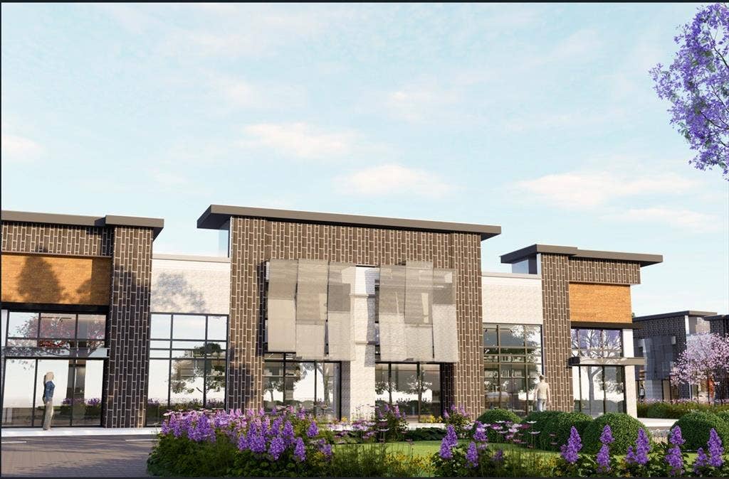1305 Summit View Lane, #110, Celina, TX 75009 Modern commercial building with brick and light-toned facade, featuring extensive glass window frontage, flat rooflines, and integrated exterior lighting