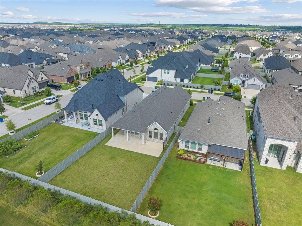1821 Stonewall Road, Argyle, TX 76226 Aerial perspective showcasing a residential neighborhood with uniformly designed homes featuring dark gray shingle roofs