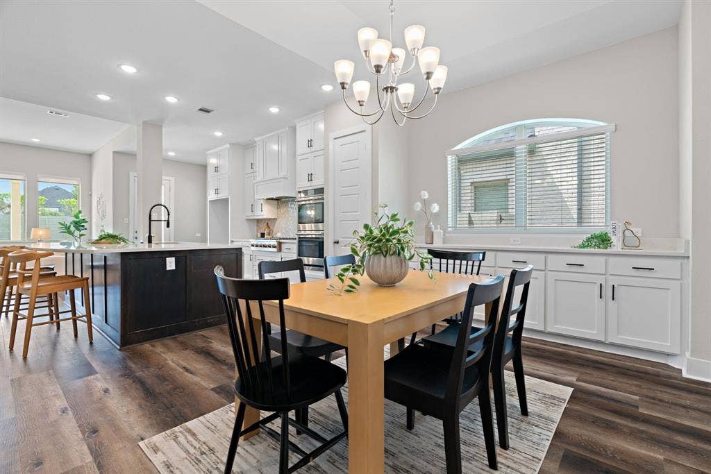 1821 Stonewall Road, Argyle, TX 76226 Open-concept dining area featuring wood-finish flooring, a contemporary chandelier, and a built-in buffet with white cabinetry and a light-toned countertop