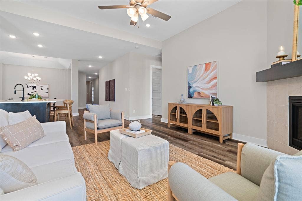 1821 Stonewall Road, Argyle, TX 76226 Living area featuring wood-finish flooring, a fireplace with a light-colored tile surround, and a dark mantel