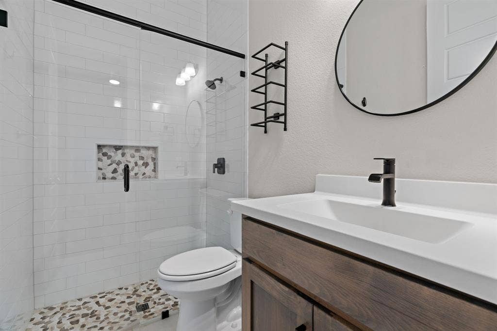 1821 Stonewall Road, Argyle, TX 76226 Contemporary bathroom featuring a walk-in shower with white subway tile, a pebble-finish shower floor, and a recessed niche