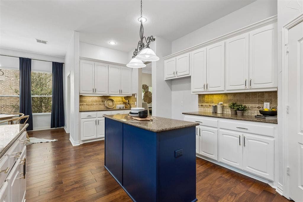 7975 Bishop Drive, Frisco, TX 75036 Kitchen featuring an island, granite countertops, white cabinetry, stainless steel appliances, engineered hardwood flooring, and walk in pantry.