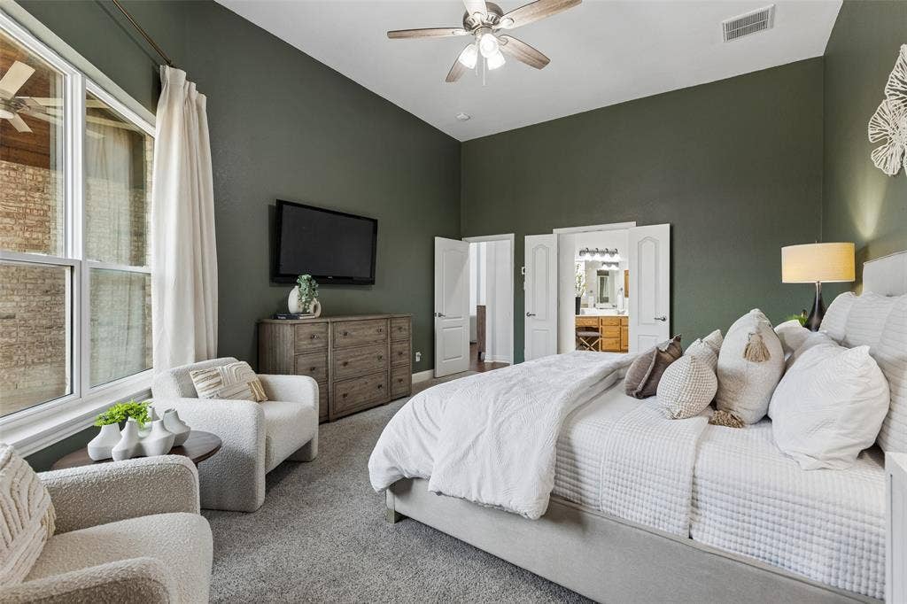 7975 Bishop Drive, Frisco, TX 75036 Spacious main level primary bedroom with vaulted ceilings, room for a sitting area, en-suite bathroom, and walk in closet.