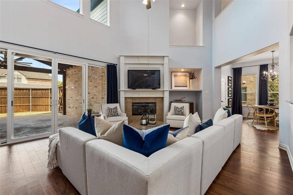 7975 Bishop Drive, Frisco, TX 75036 Soaring two-story living room 2 story vaulted living room with tons of natural light, engineered hardwood floors, and gas fireplace.