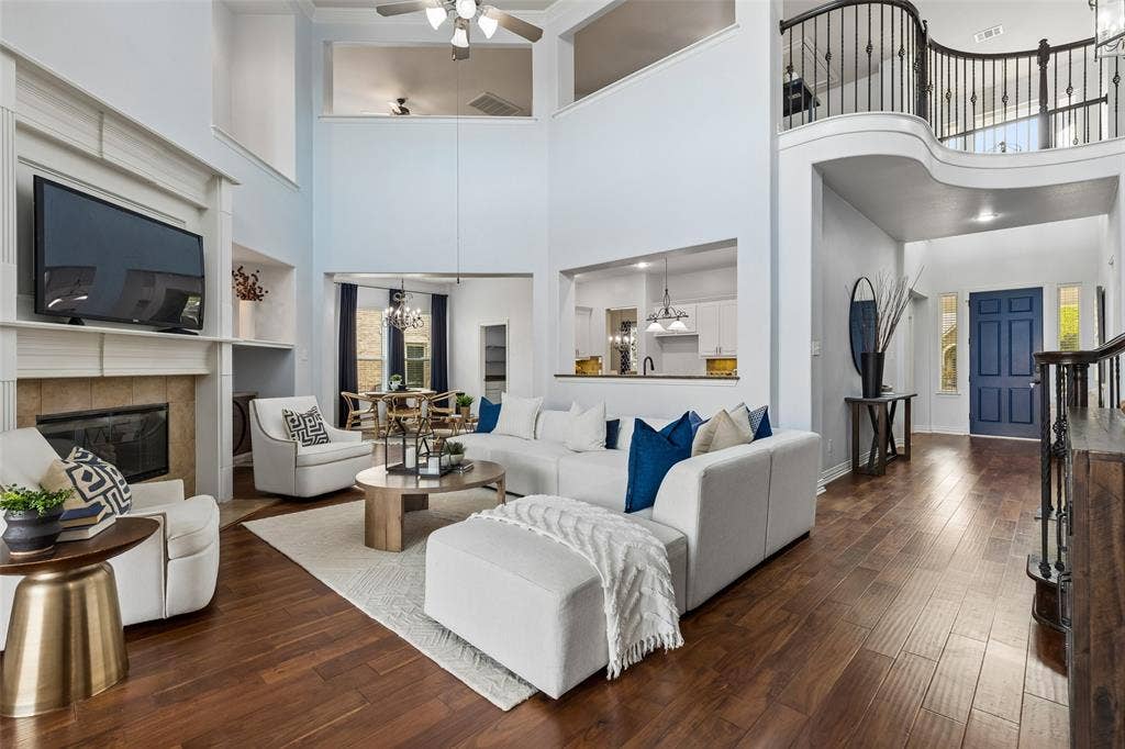 7975 Bishop Drive, Frisco, TX 75036 Soaring 2 story vaulted living room with tons of natural light, engineered hardwood floors, and gas fireplace.
