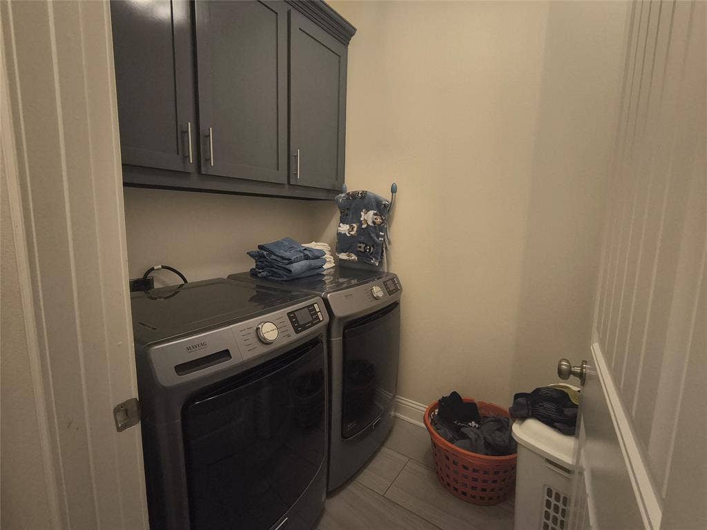 3027 Ames Road, Lancaster, TX 75134 Dedicated laundry area featuring overhead cabinetry, tile flooring, and neutral wall tones