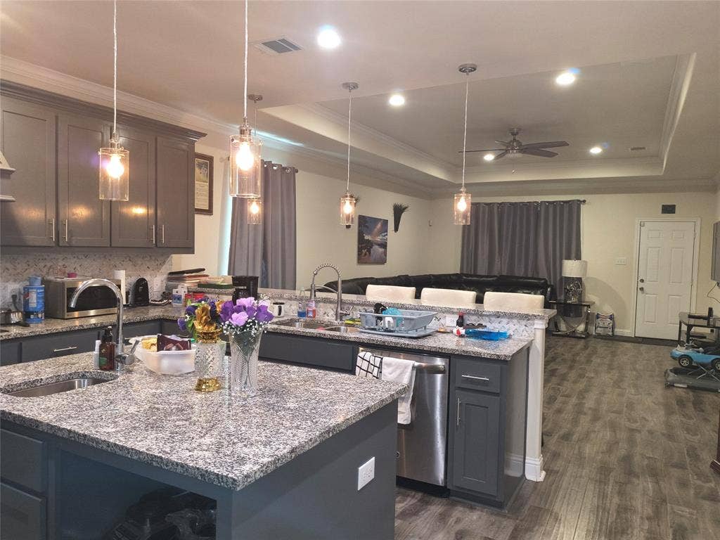 3027 Ames Road, Lancaster, TX 75134 Open-concept kitchen featuring gray cabinetry, granite countertops, and a complementary backsplash